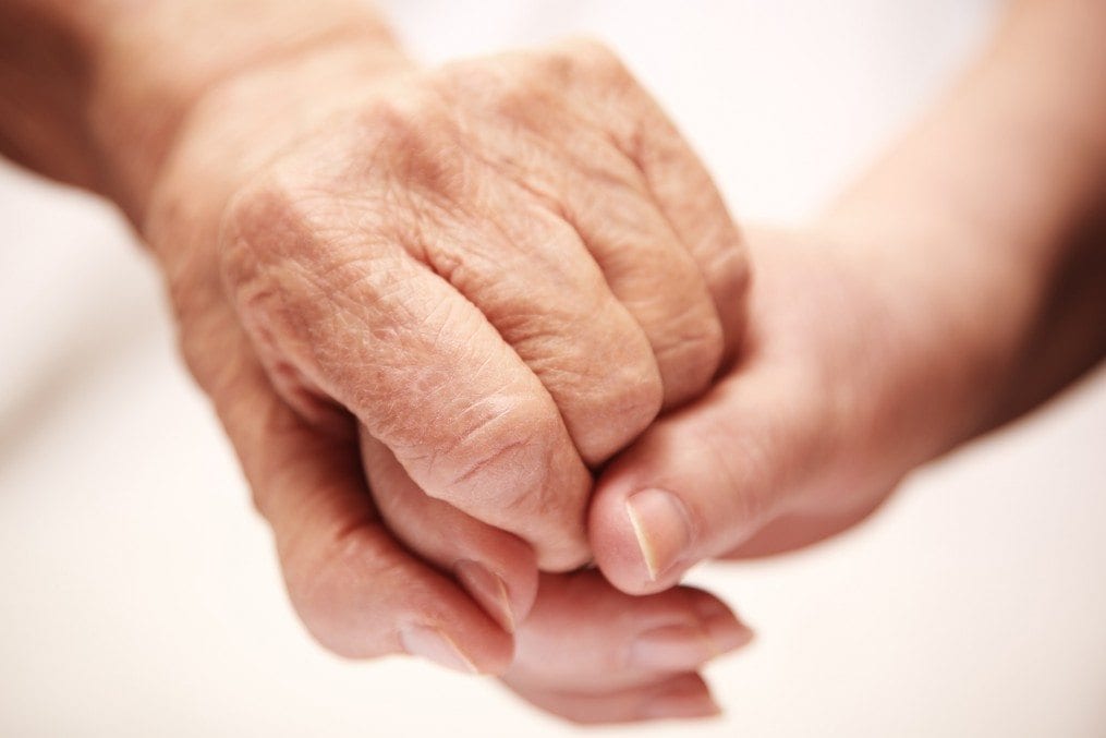 adult helping senior with dementia