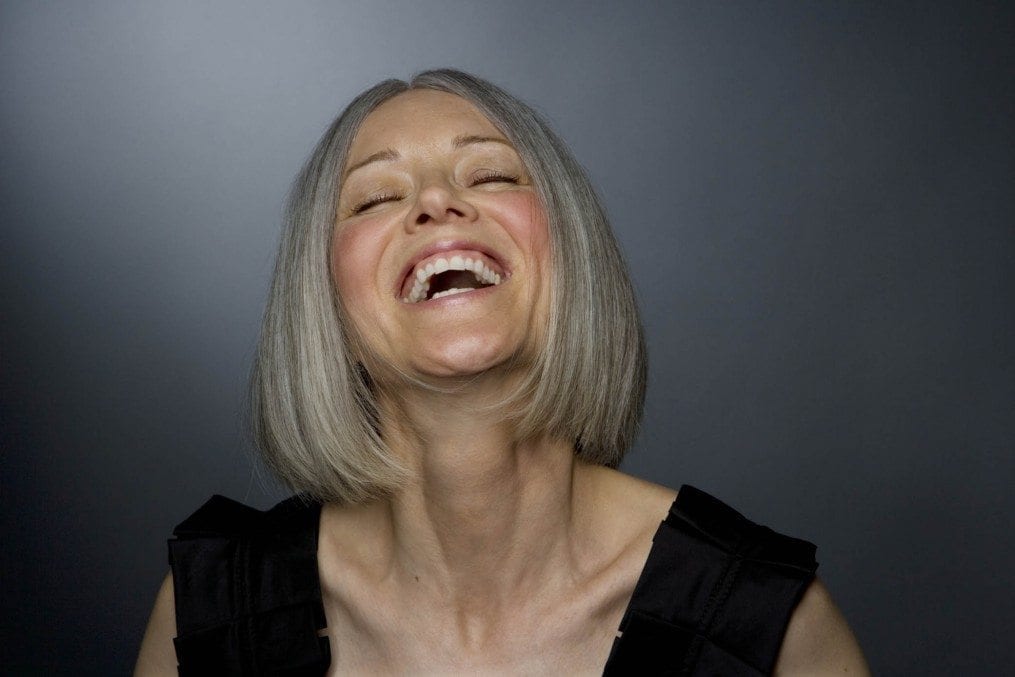Mature woman laughing, eyes closed