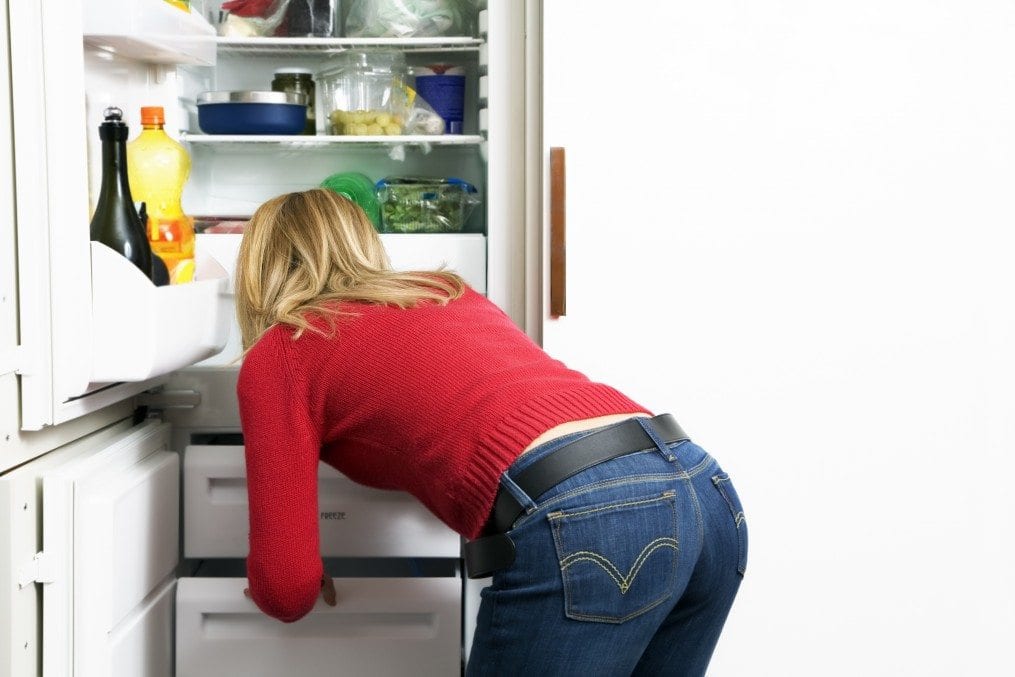 woman looking for food in fridge