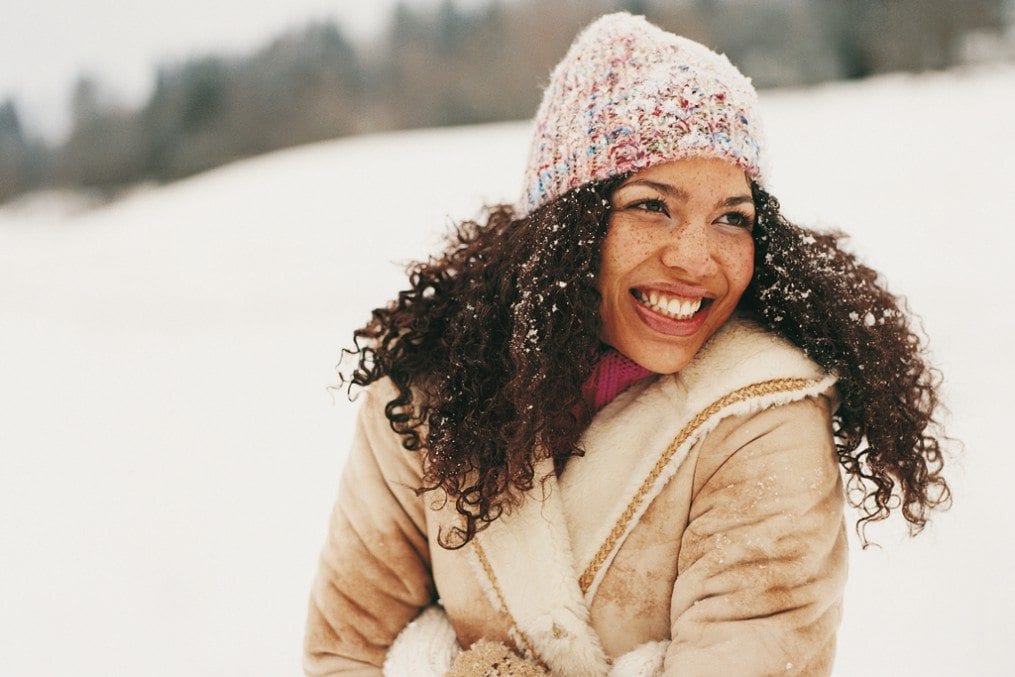 Woman smiling surrounded by snow